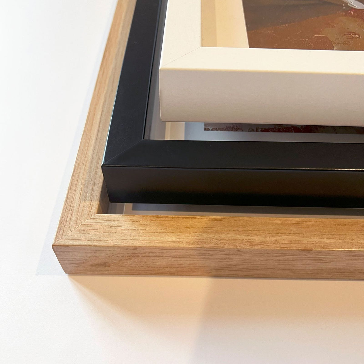Corner detail of art print frames in oak, black and white