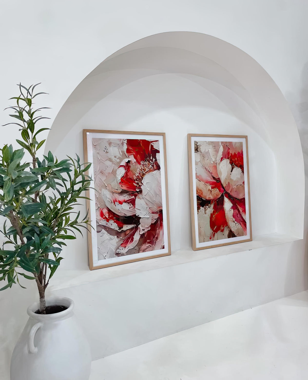 Two oak-framed art prints displayed in an arched alcove